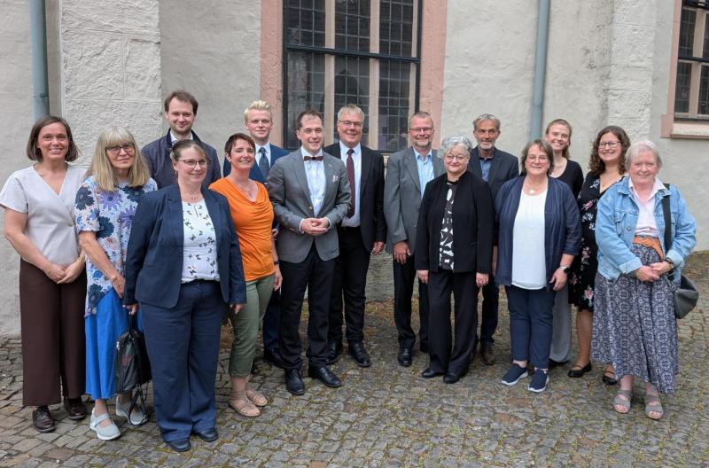 Verabschiedung Superintendent Dr. Sven Lesemann - Dr. Sven Lesemann zusammen mit Mitgliedern des Kirchenvorstandes Lage und Beteiligten am Abschiedsgottesdienst Viele Leute stehen in einem Halbkreis vor der Martkirche Lage